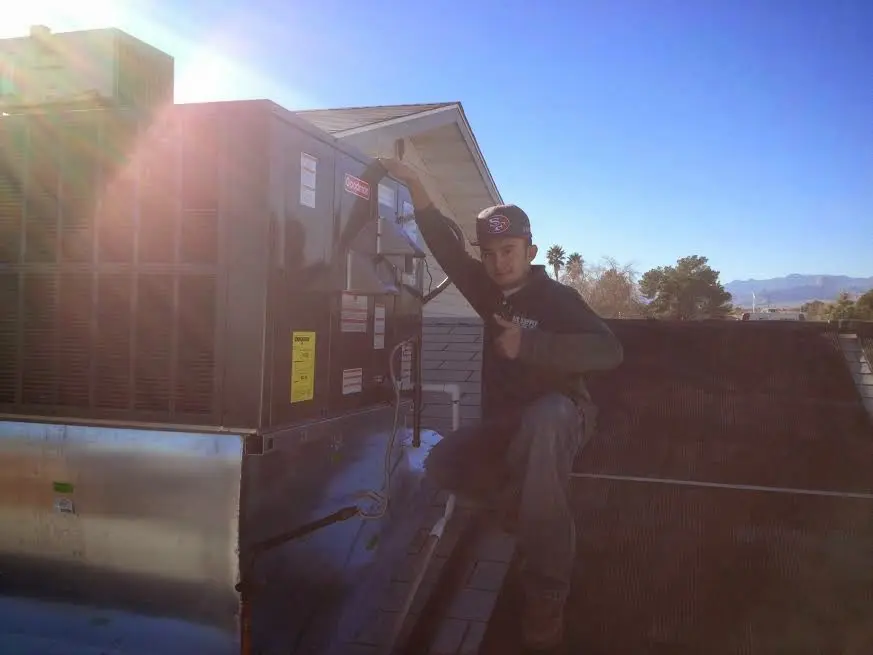 HVAC technician performing AC Tune-Up on a rooftop unit in Calumet